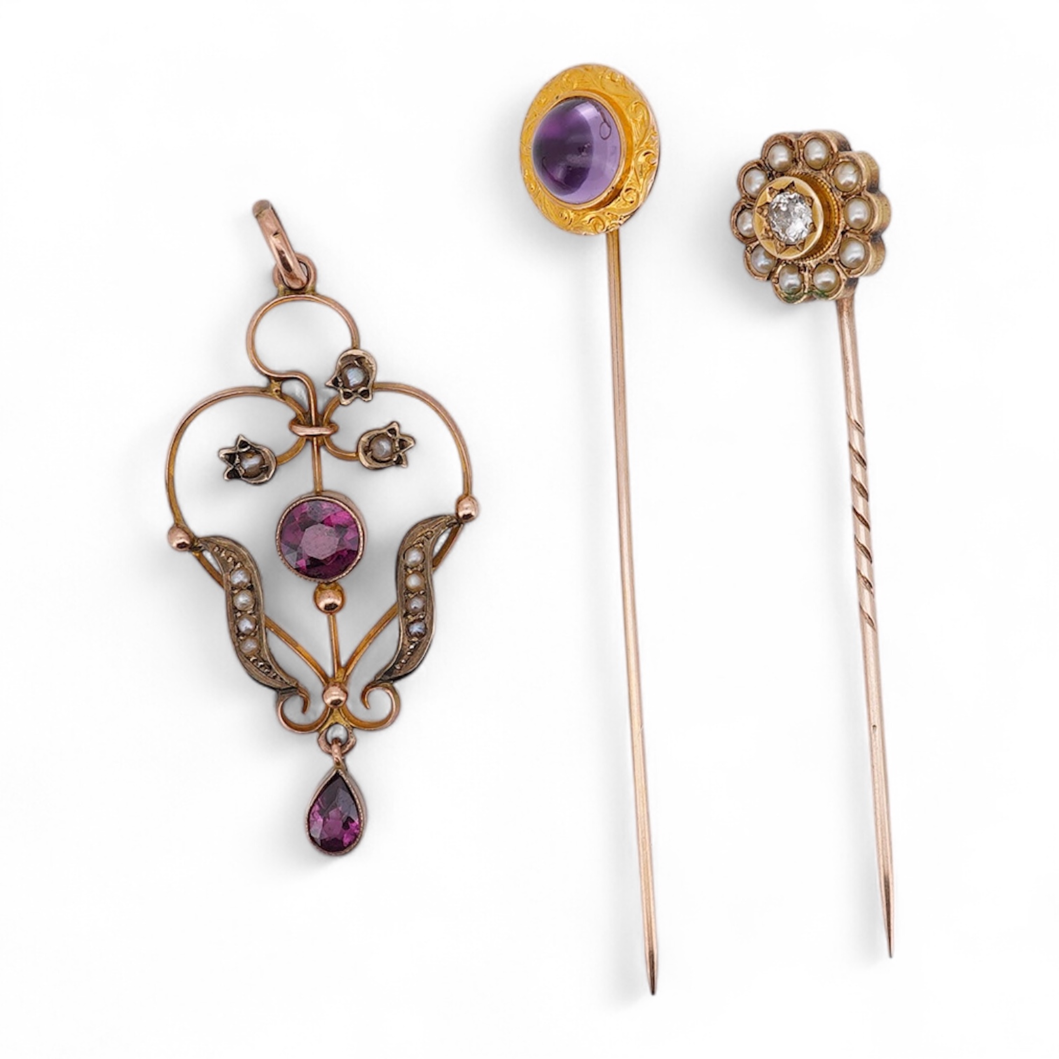 An Edwardian 15ct, diamond and seed pearl cluster set stick pin, 54mm, a similar yellow metal and cabochon garnet set stick pin and an Edwardian 9ct and gem set drop pendant. Condition - poor to fair
